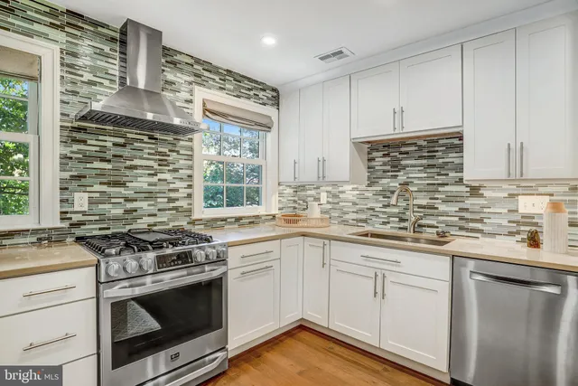 a kitchen with granite countertop a stove sink and cabinets