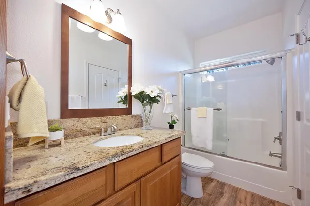 a bathroom with a granite countertop sink toilet and shower