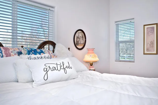 a bed with a large window and table chair