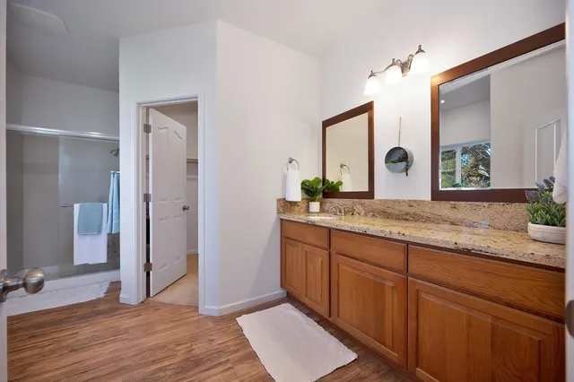 a bathroom with a granite countertop sink and a mirror