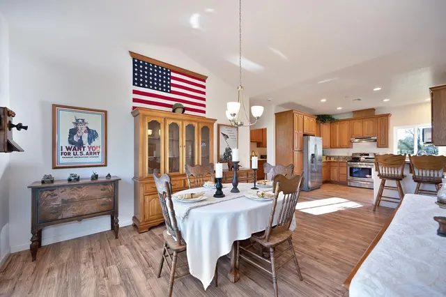 a living room with furniture kitchen view and a wooden floor