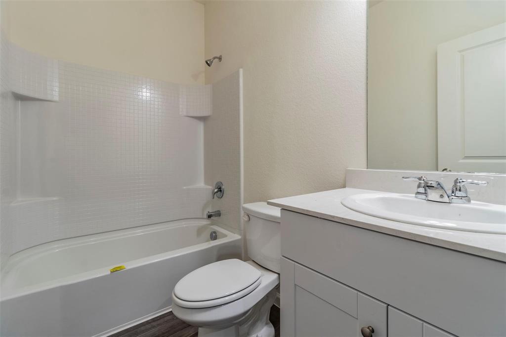 1848 McCree Street Forney, TX 75126 - Photo 13 of 33 a bathroom with a granite countertop toilet a sink and a bathtub