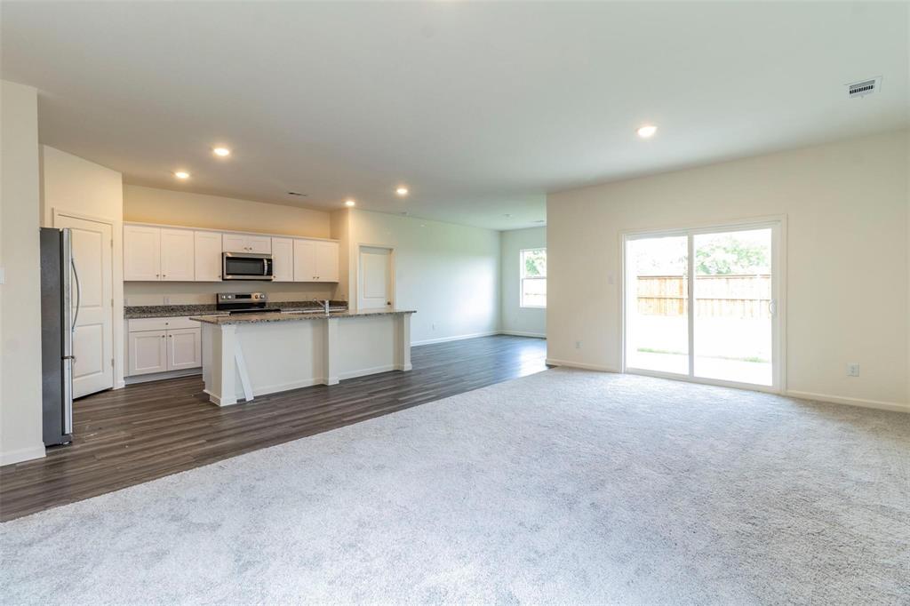 1848 McCree Street Forney, TX 75126 - Photo 32 of 33 a kitchen with stainless steel appliances kitchen island granite countertop a stove top oven a sink and a refrigerator