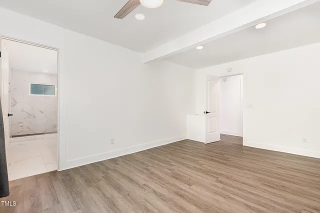 a view of an empty room with wooden floor