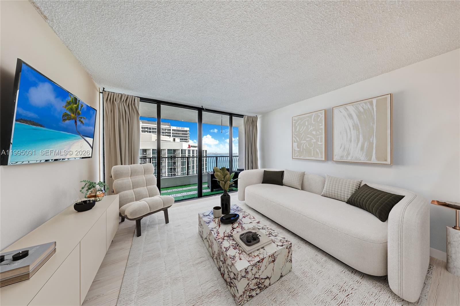 555 Northeast 15th Street, Unit 33G Miami, FL 33132 - Photo 4 of 18 a living room with furniture and a flat screen tv