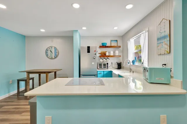 a view of kitchen with kitchen island stainless steel appliances and living room view