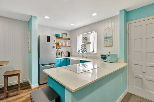 a view of a kitchen area with furniture and wooden floor