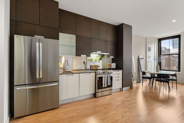 a kitchen with granite countertop stainless steel appliances a refrigerator a stove a dining table and chairs