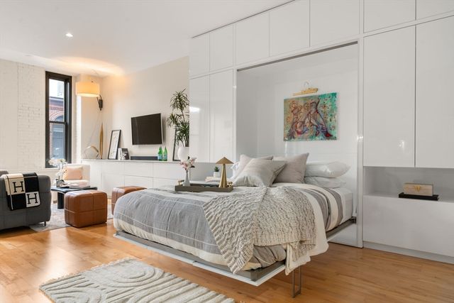 a spacious bedroom with a bed a couch and a flat screen tv