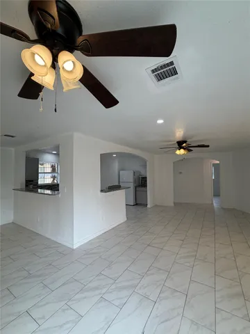 a view of a livingroom with furniture and chandelier fan