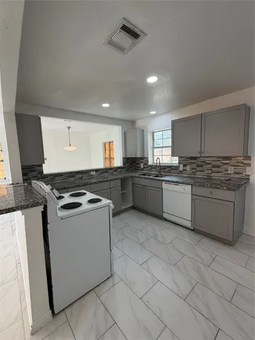 a kitchen with stainless steel appliances granite countertop a stove sink and cabinets