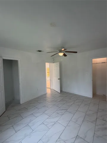 an empty room with chandelier fan