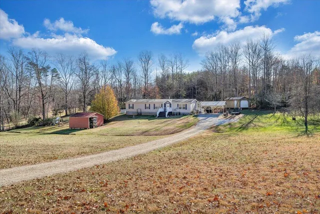 a view of a swimming pool with a yard and wooden fence