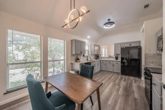 a open dining room with kitchen island furniture a large window and stainless steel appliances