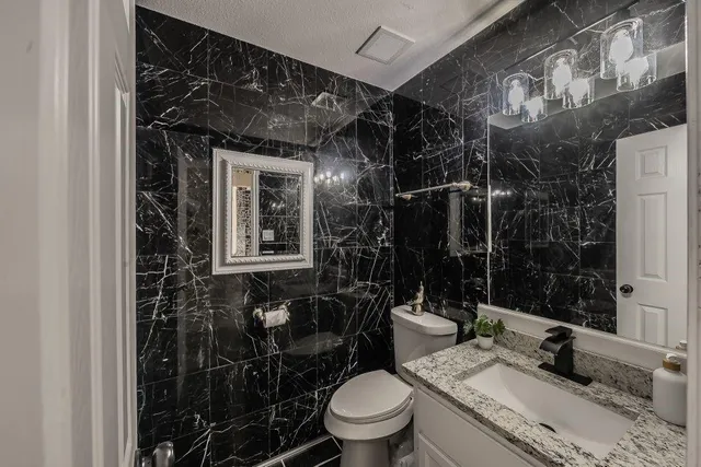 a bathroom with a toilet a sink and mirror