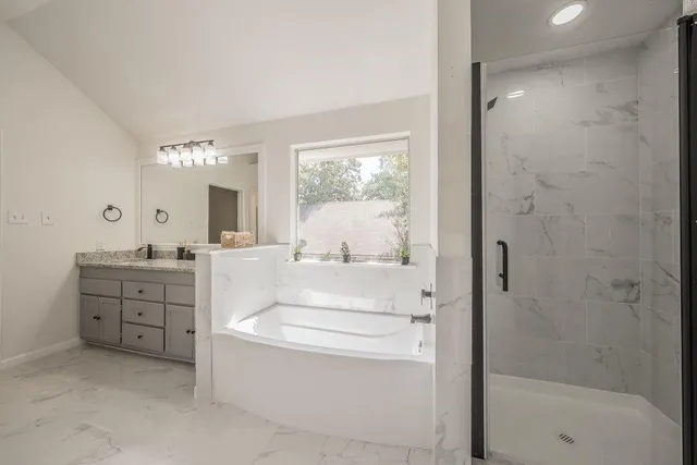 a bathroom with a tub sink and mirror