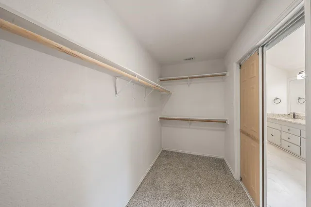 a view of walk in closet with empty racks