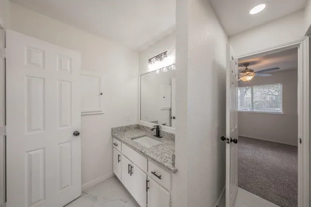 a bathroom with a granite countertop sink a mirror and a