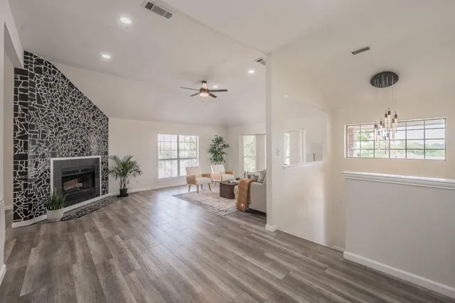 a view of a livingroom with wooden floor and a fireplace