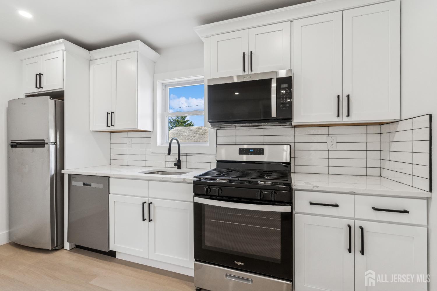 318 Seaman Street, Unit 1 New Brunswick, NJ 08901 - Photo 4 of 14 a kitchen with cabinets stainless steel appliances and a sink