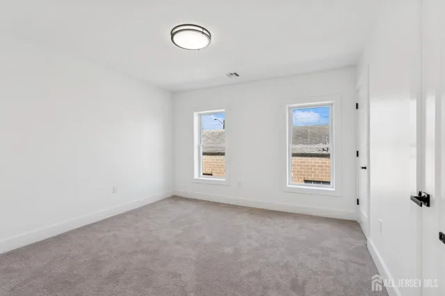 an empty room with windows and closet