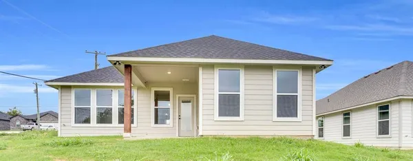 a front view of a house with a garden and yard