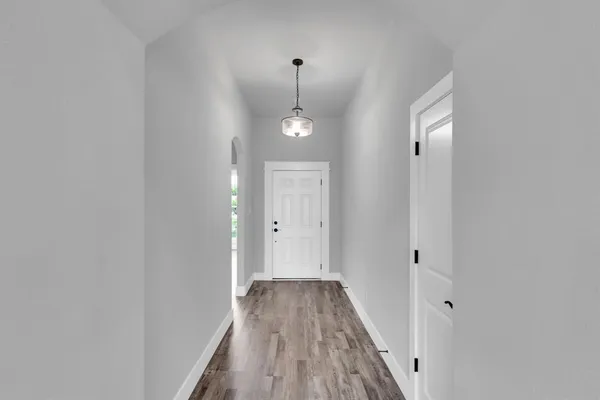 a view of a hallway with wooden floor and staircase