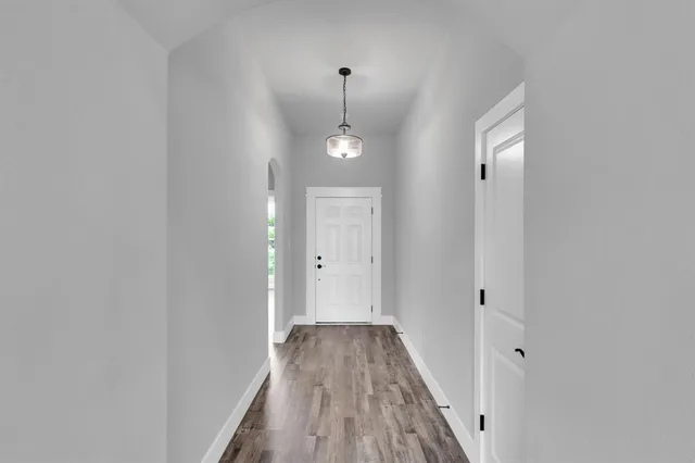 a view of a hallway with wooden floor and staircase