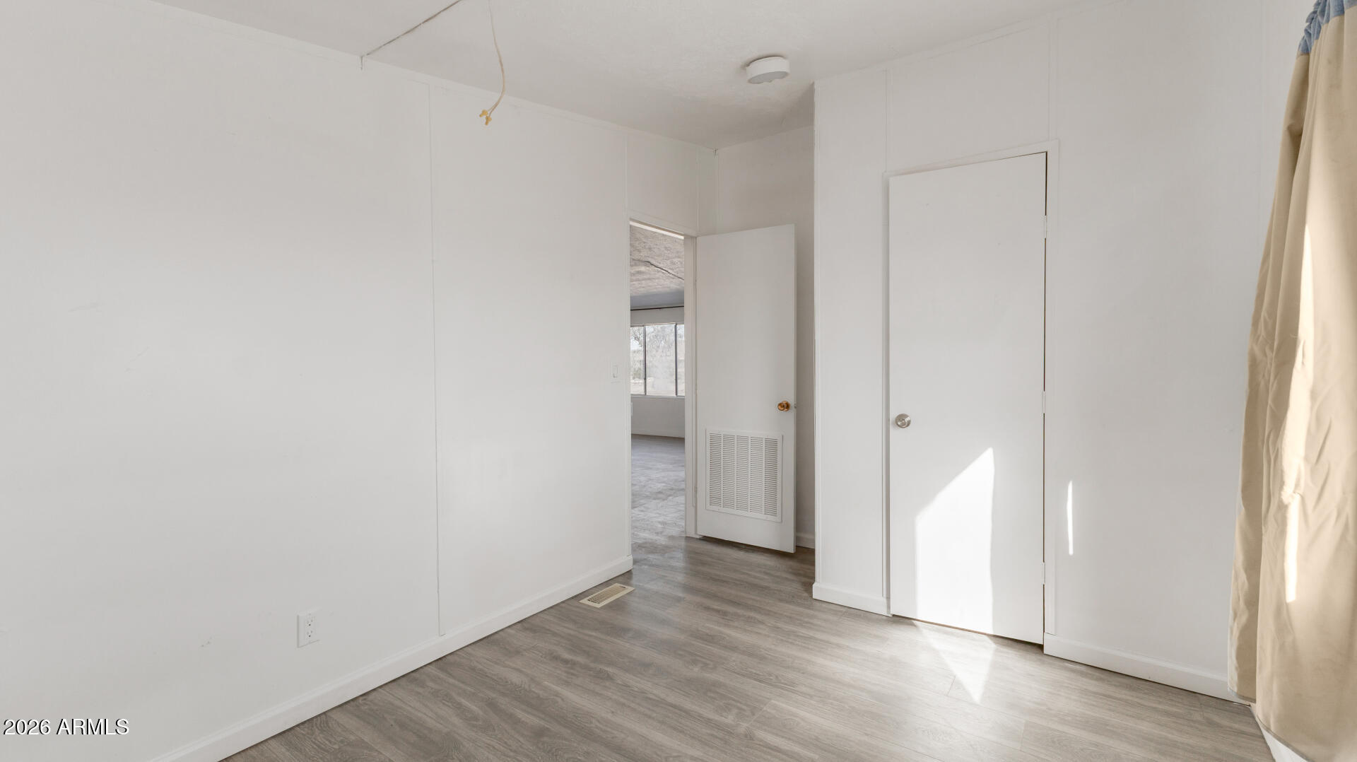54073 West Stallion Road Maricopa, AZ 85139 - Photo 16 of 23 a view of an empty room with wooden floor and a window