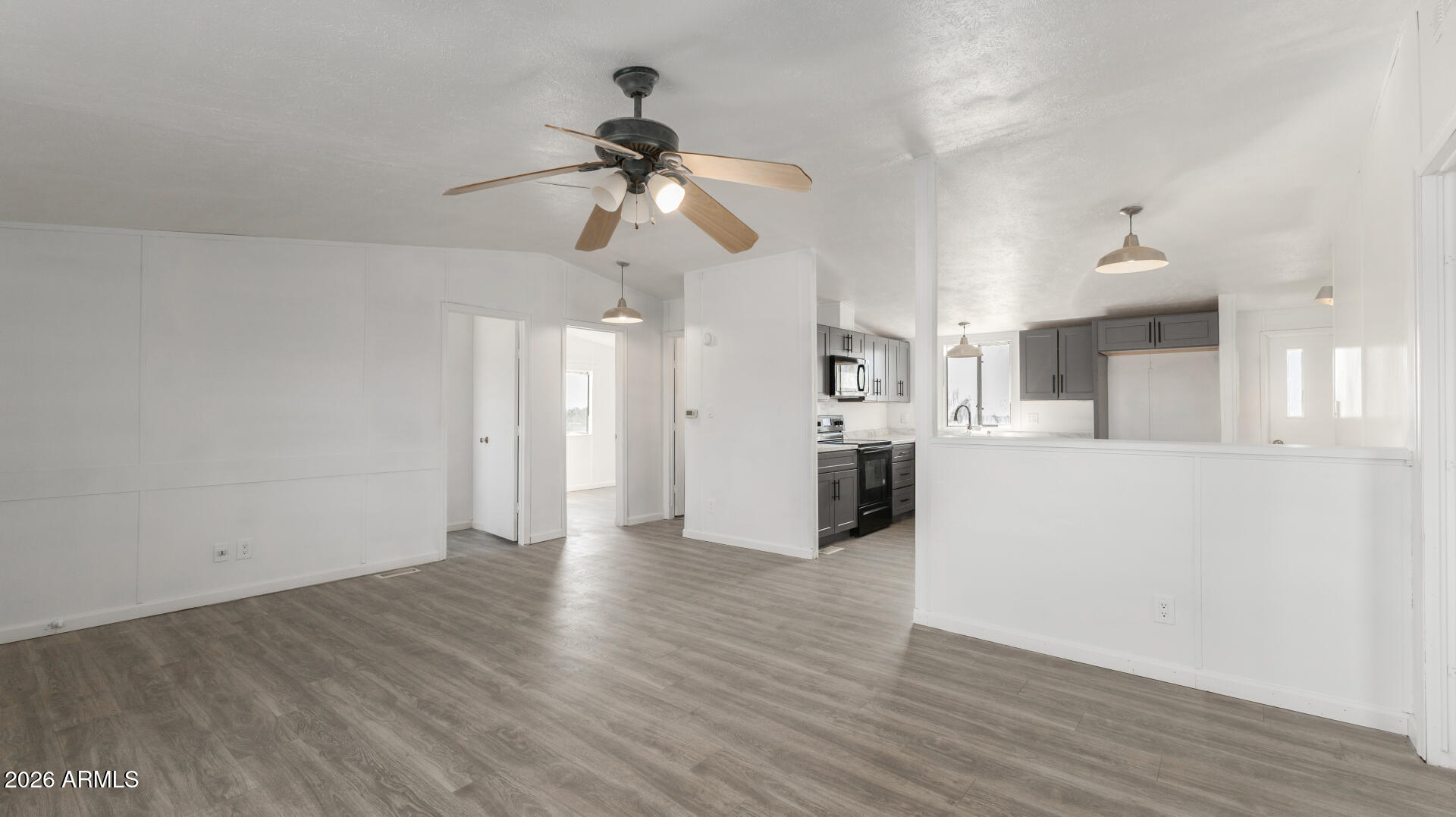 54073 West Stallion Road Maricopa, AZ 85139 - Photo 2 of 23 a view of a kitchen with wooden floor and a ceiling fan