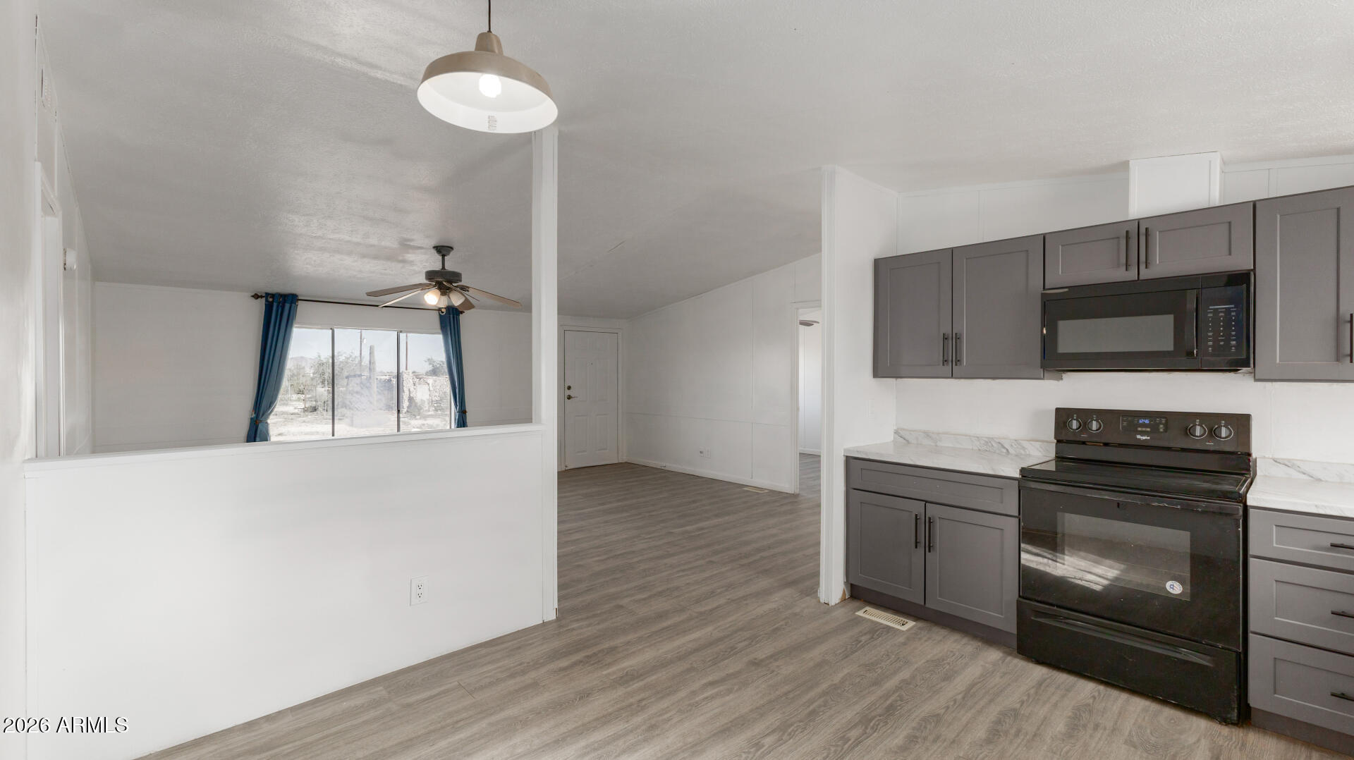 54073 West Stallion Road Maricopa, AZ 85139 - Photo 3 of 23 a kitchen with stainless steel appliances a stove microwave and cabinets