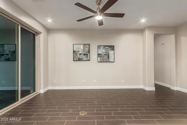 a view of a livingroom with a ceiling fan & hardwood floor