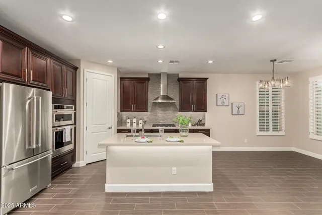 a large kitchen with kitchen island a large counter top stainless steel appliances and cabinets