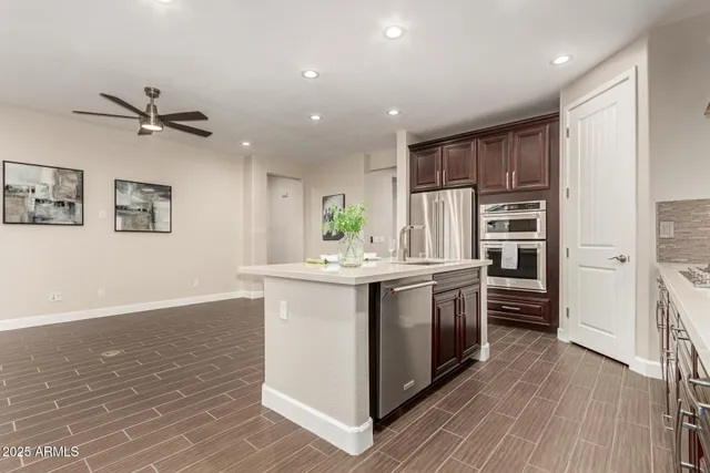 a kitchen with stainless steel appliances granite countertop a white cabinets and wooden floor