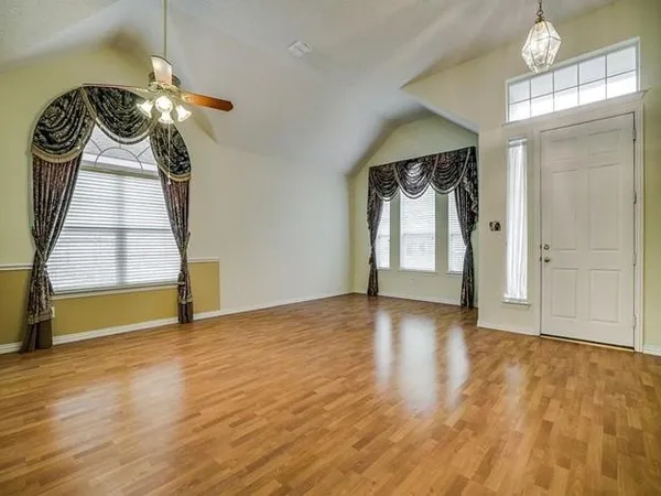 a view of empty room with wooden floor