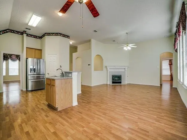 a view of an empty room with a fireplace and chandelier