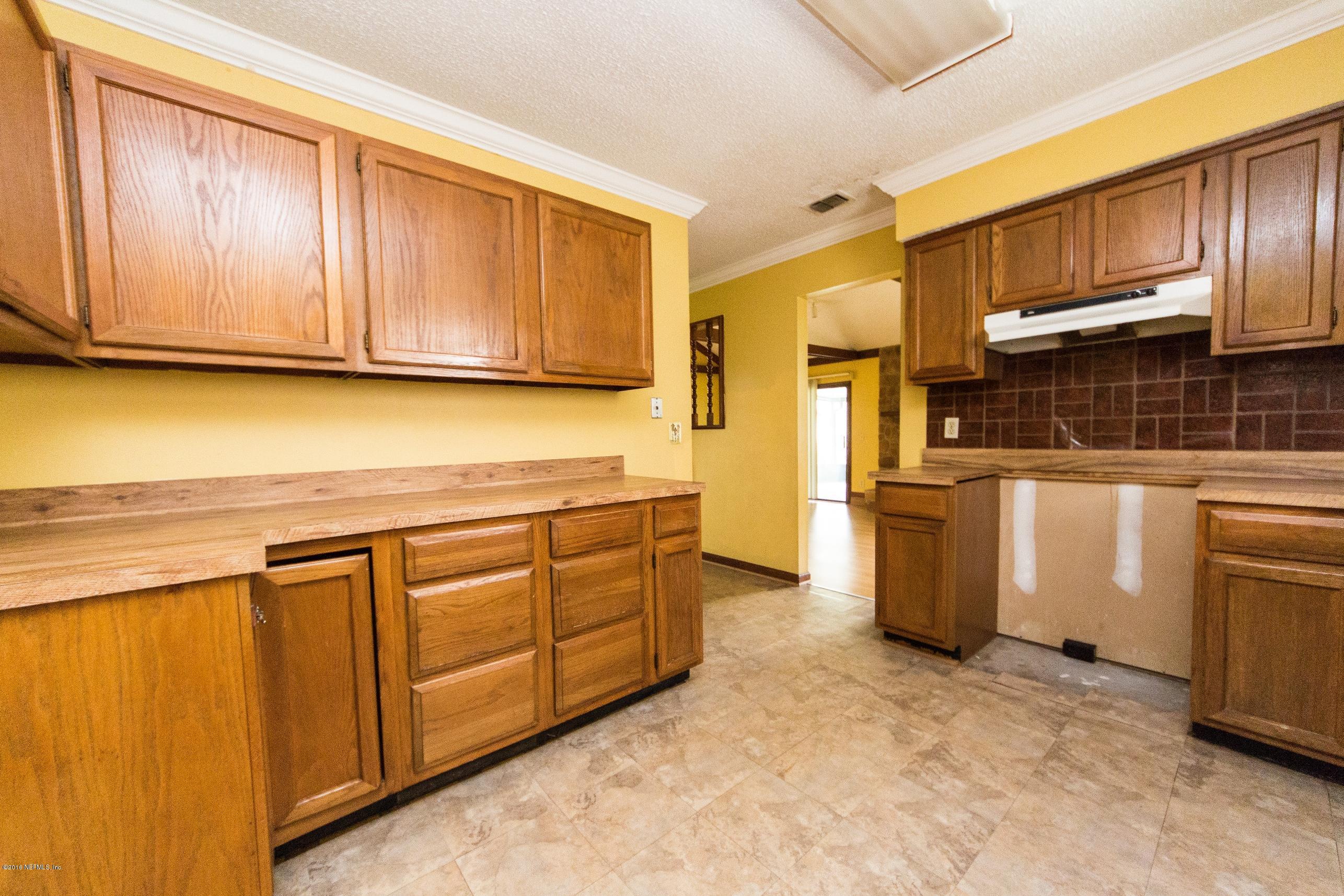 10852 Reading Road Jacksonville, FL 32257 - Photo 14 of 30 a kitchen with stainless steel appliances granite countertop a refrigerator a stove top oven and a sink with wooden cabinets