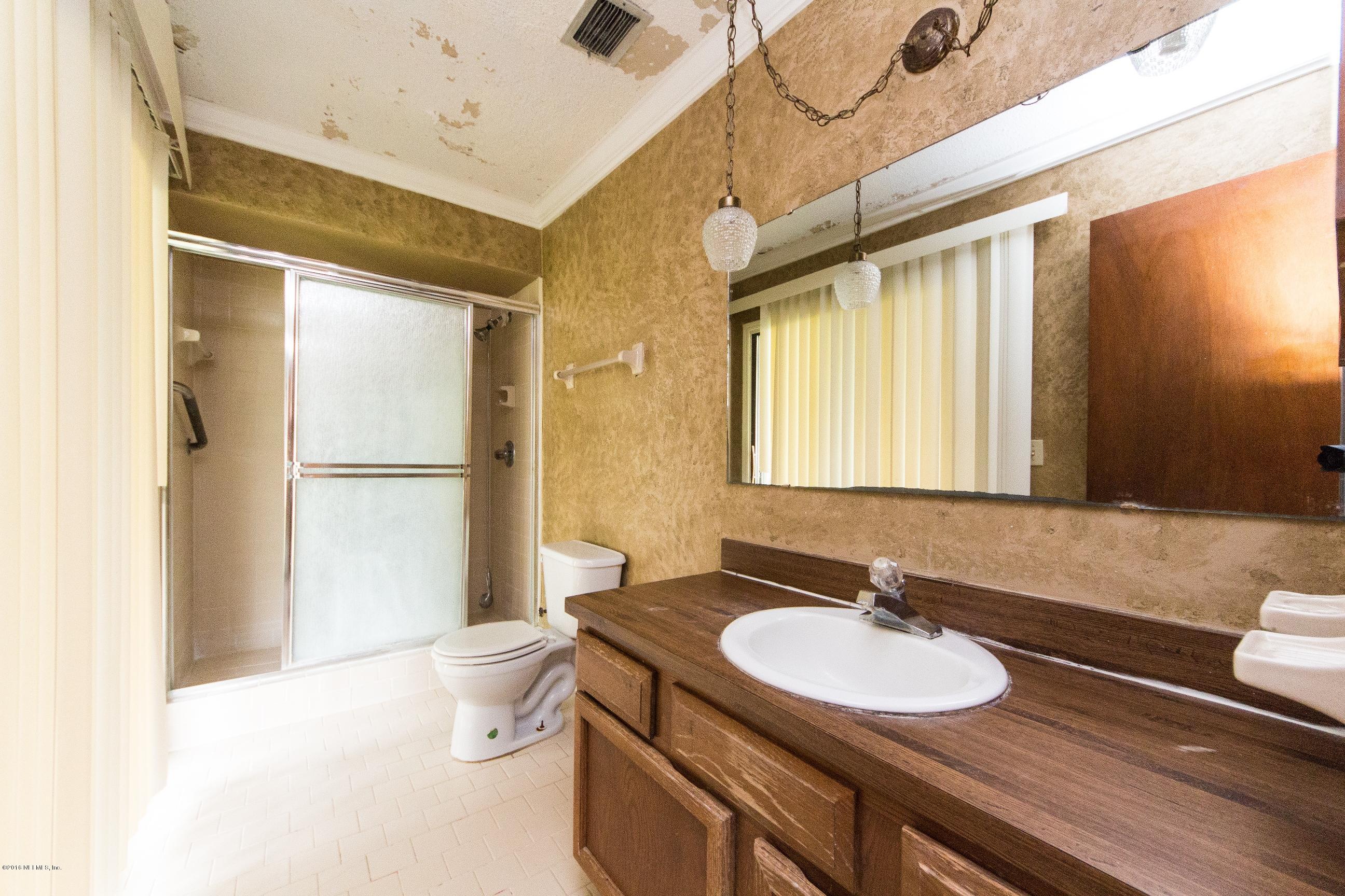 10852 Reading Road Jacksonville, FL 32257 - Photo 18 of 30 a bathroom with a granite countertop sink toilet and shower