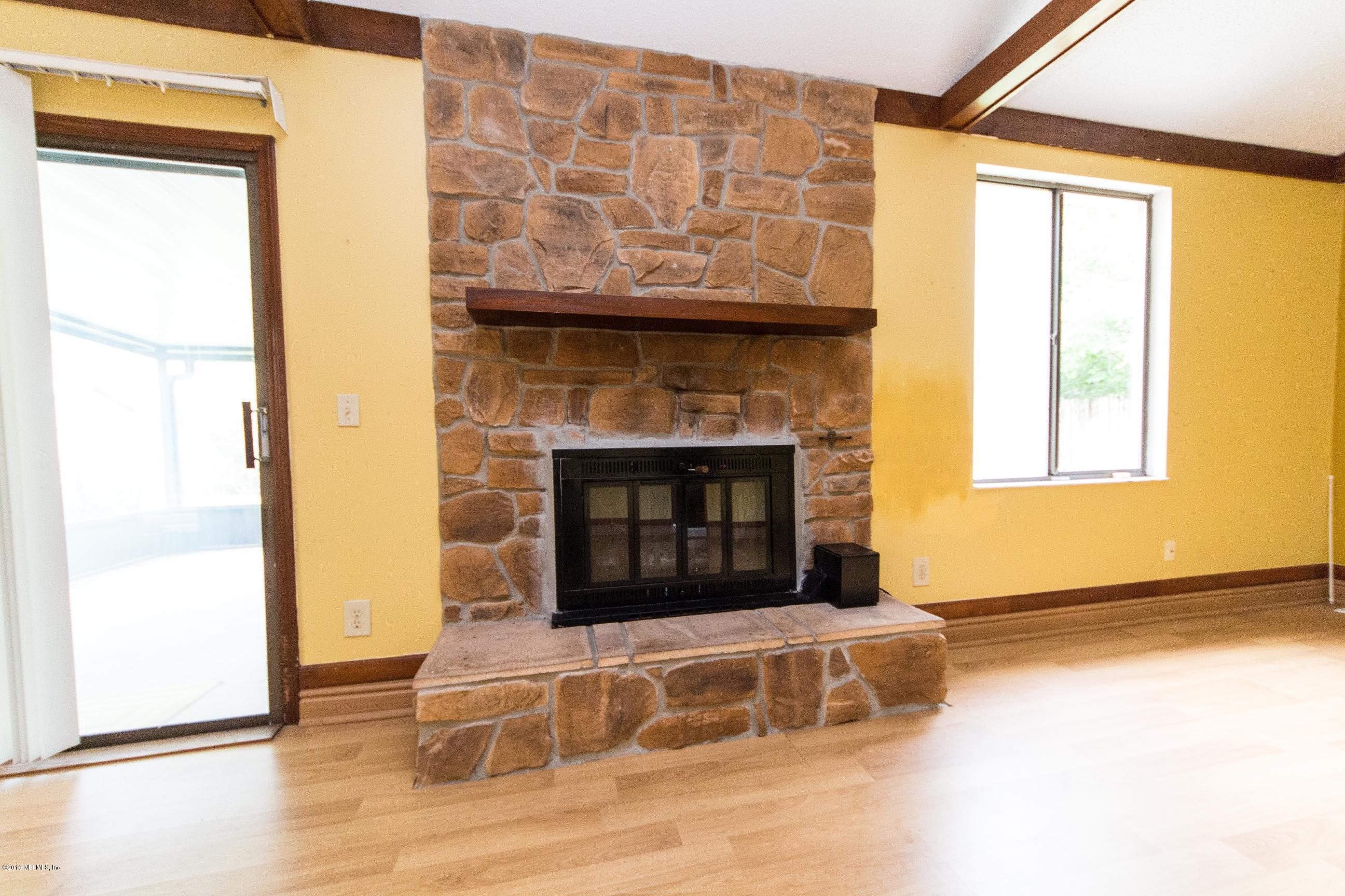 10852 Reading Road Jacksonville, FL 32257 - Photo 9 of 30 a living room with a fireplace and a wooden floor