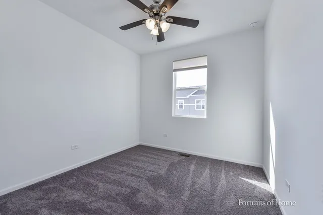 an empty room with closet and a chandelier fan