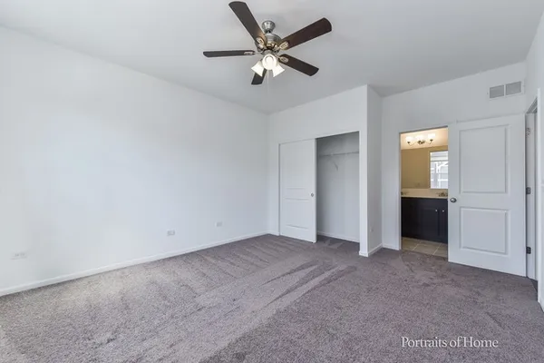 an empty room with closet and windows
