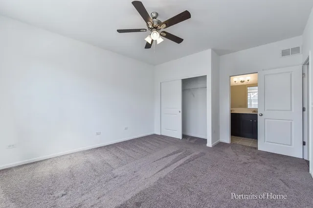 an empty room with closet and windows
