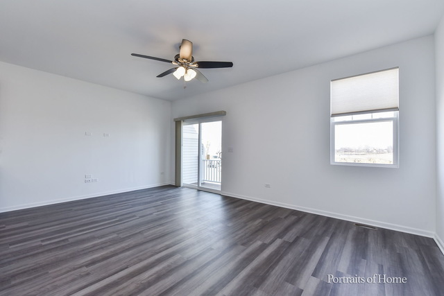 4189 Chelsea Manor Circle Aurora, IL 60504 - Photo 9 of 19 an empty room with wooden floor fan and windows