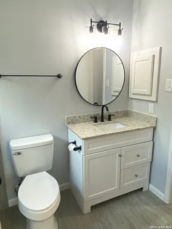 a bathroom with a granite countertop toilet sink and shower