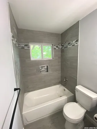 an empty room with a ceiling fan and window