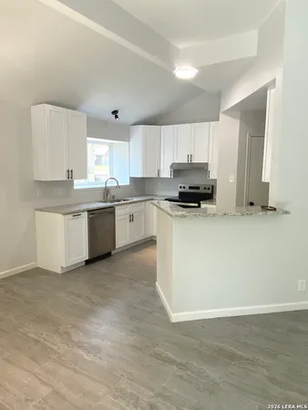 a kitchen with granite countertop white cabinets and white appliances