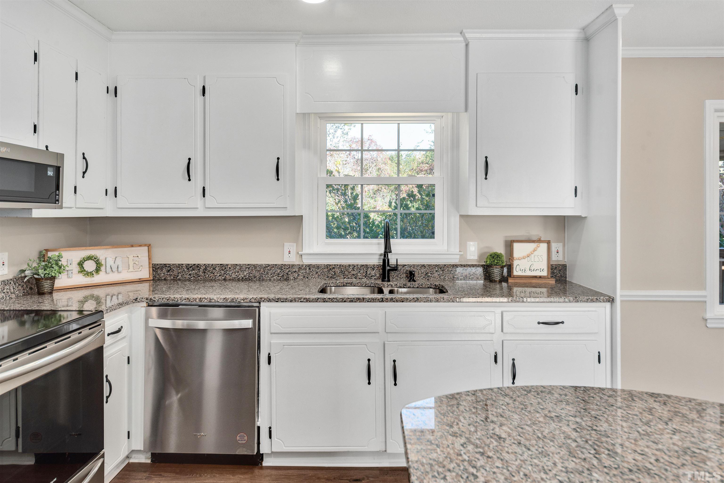 5630 Fairground Road Dunn, NC 28334 - Photo 11 of 33 a kitchen with granite countertop white cabinets and white appliances
