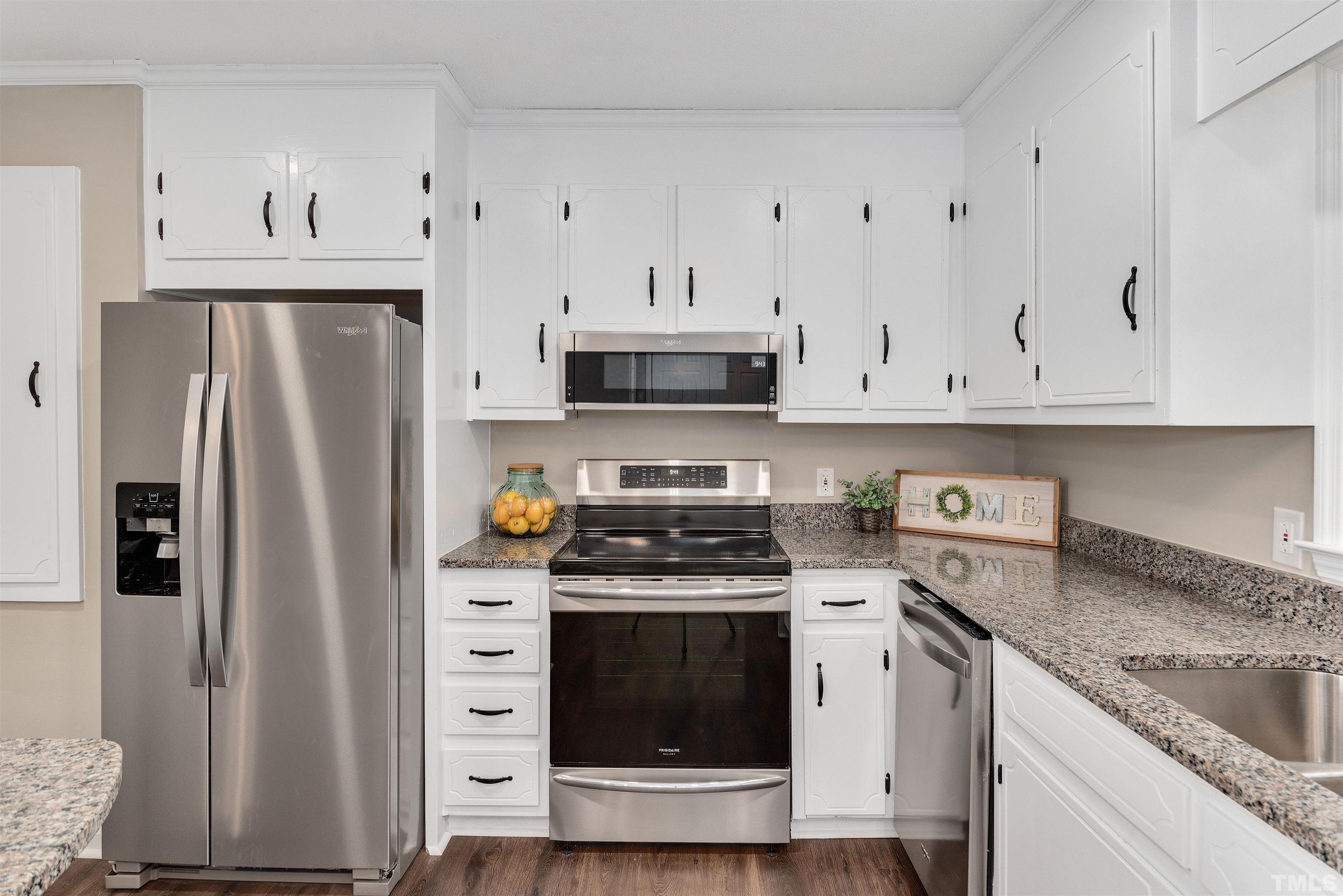 5630 Fairground Road Dunn, NC 28334 - Photo 12 of 33 a kitchen with stainless steel appliances granite countertop a refrigerator stove and white cabinets