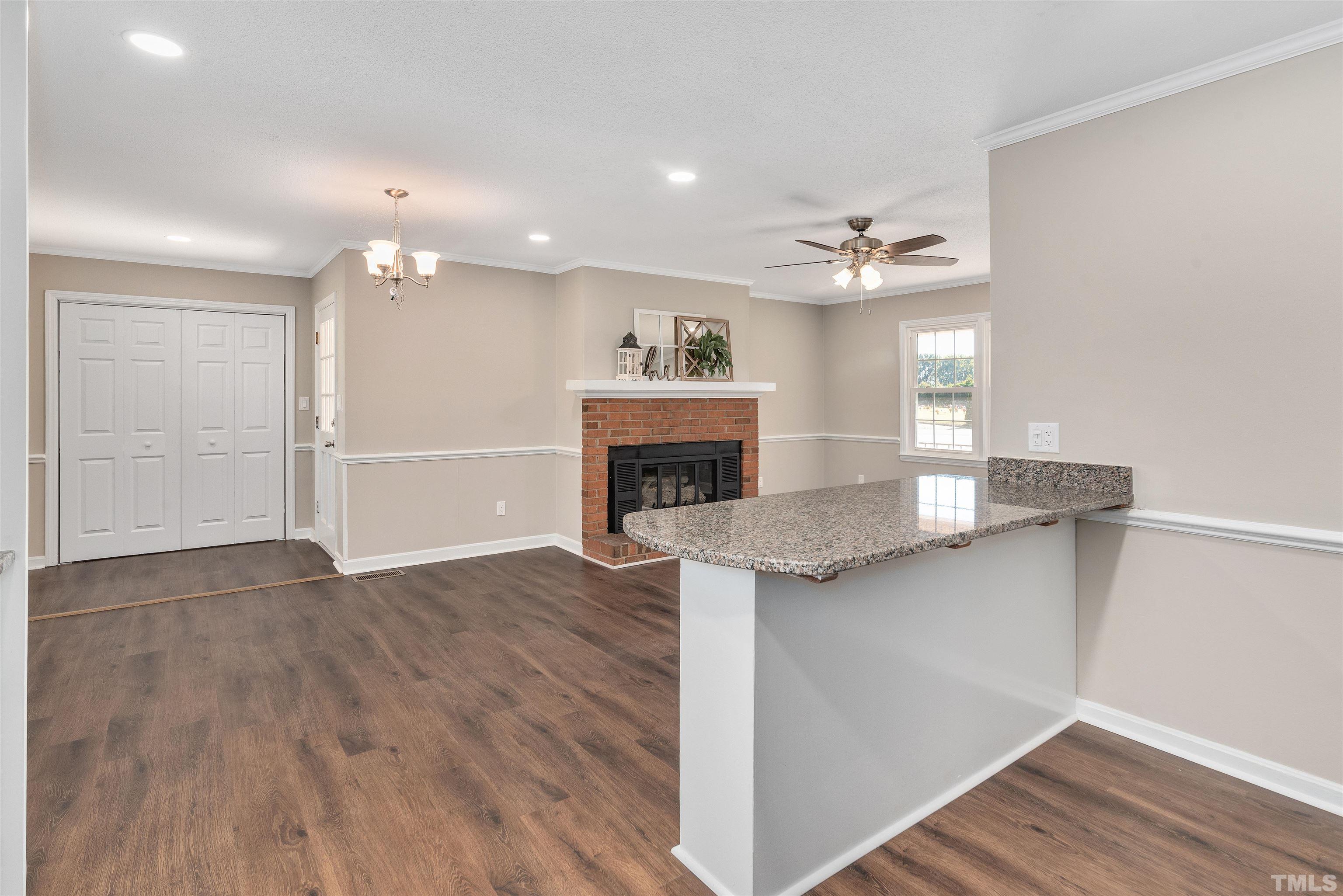 5630 Fairground Road Dunn, NC 28334 - Photo 13 of 33 wooden floor in an empty room with a fireplace