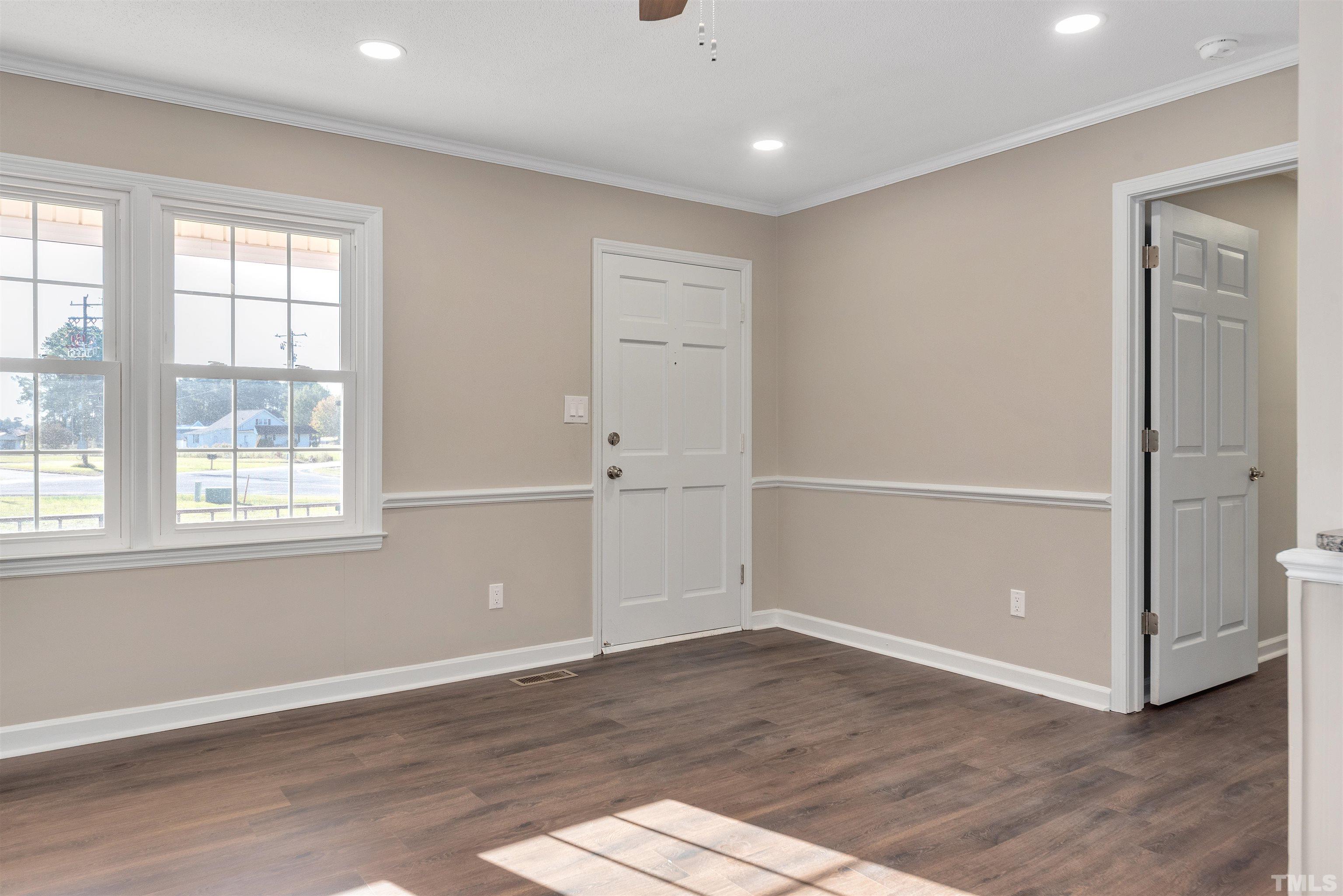 5630 Fairground Road Dunn, NC 28334 - Photo 2 of 33 an empty room with wooden floor cabinet and windows